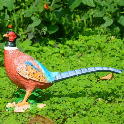 公園里擺放著一只長尾巴的玻璃鋼彩繪雞雕塑