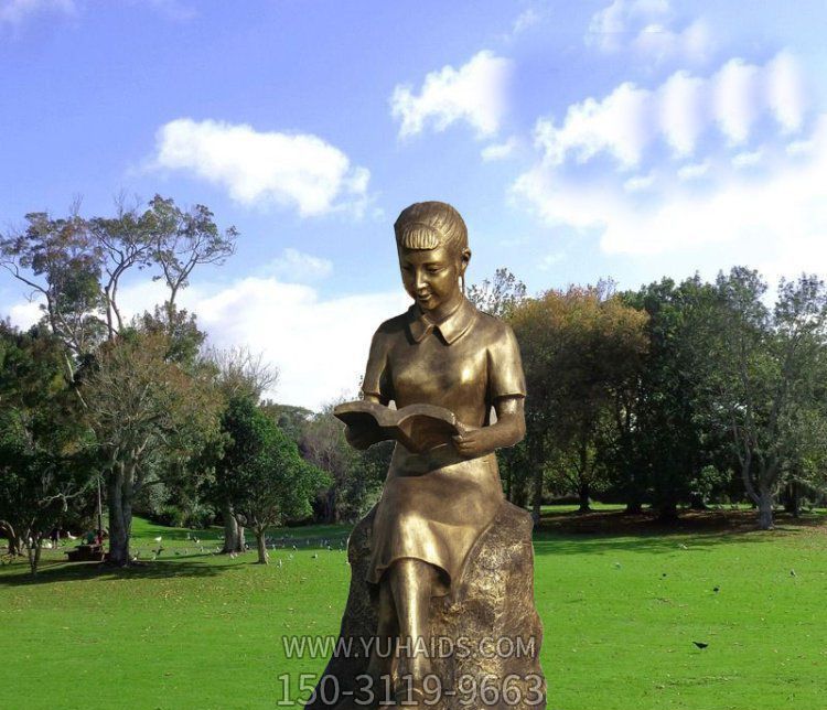 公園草坪女孩坐著石頭上的讀書雕塑