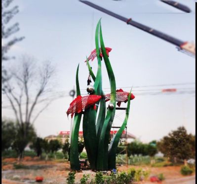 公園里擺放的水草里的不銹鋼創(chuàng)意鯉魚(yú)雕塑